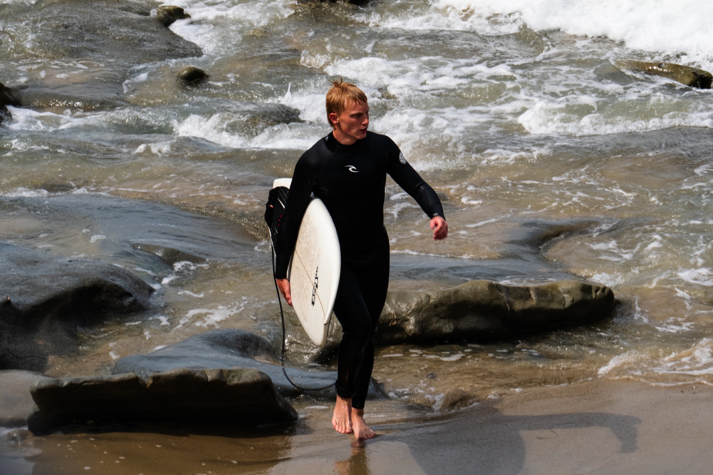 surfer walking out of the water