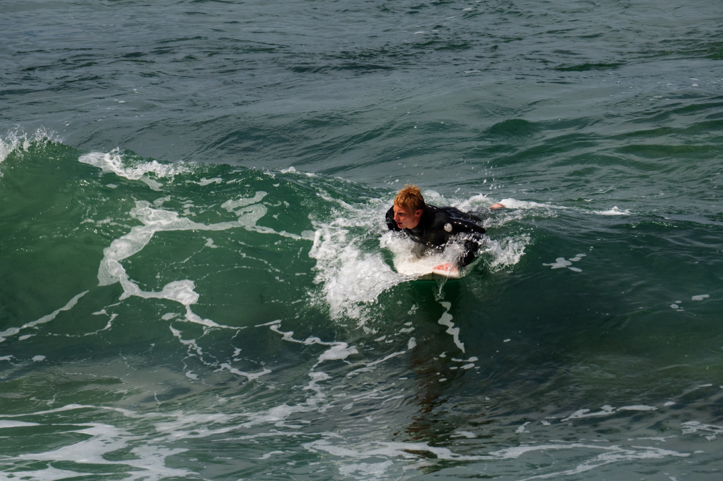 surfer paddling into a wave