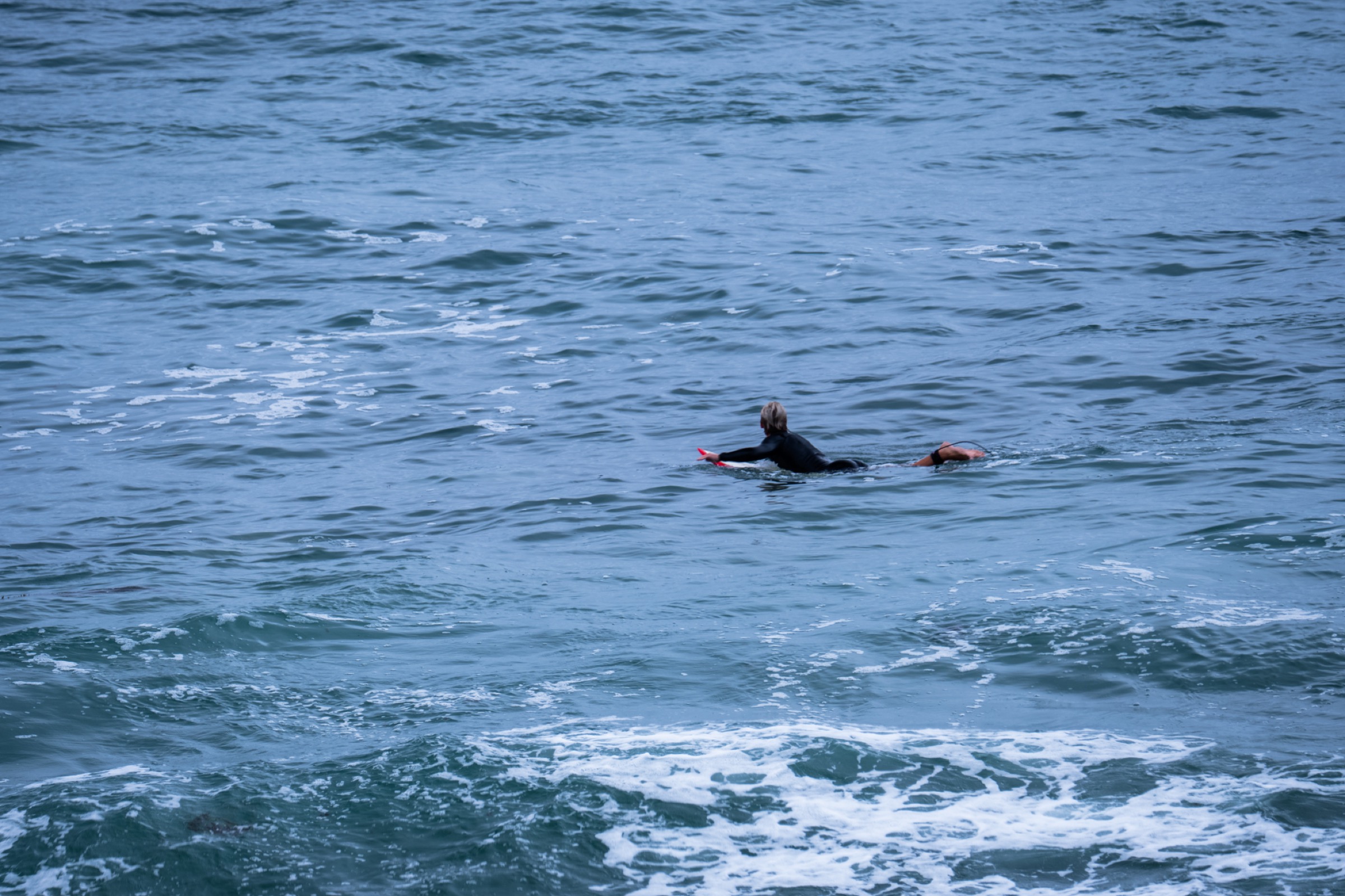 surfer paddling in open water